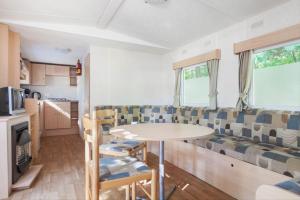 a caravan living room with a table and a couch at RA Veluwe Mobile home in Arnhem