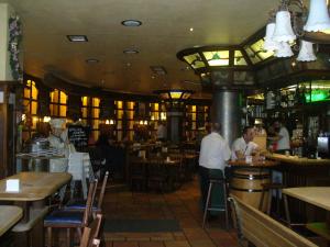 ein Restaurant mit Leuten, die an Tischen in einer Bar sitzen in der Unterkunft Ferienwohnung Rheinaue in Köln