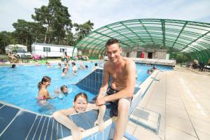 Un homme et deux filles dans une piscine dans l'établissement RA Veluwe Mobile home, à Arnhem