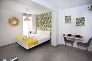 um quarto com uma cama, uma mesa e uma cadeira em MONKÓ - LEMON & TROPYCAL APARTMENT o em Torremolinos