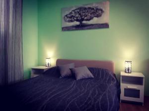 a bedroom with a bed with two night stands and a tree at Apartments Luza in Lastovo