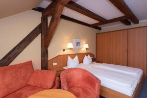 a bedroom with a bed and a couch at Hotel Europa in Görlitz