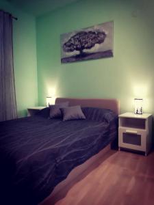 een slaapkamer met een bed en een boom aan de muur bij Apartments Luza in Lastovo