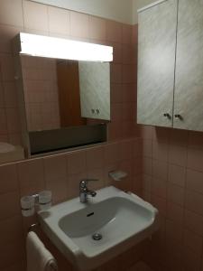 La salle de bains est pourvue d'un lavabo et d'un miroir. dans l'établissement Bed & Breakfast, à Coire