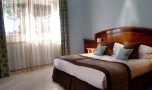 a bedroom with a large bed and a large window at Hotel Terme Marine Leopoldo II in Marina di Grosseto