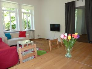 a living room with a vase of flowers on a table at Apartment Villa Elisa in Bad Kreuznach