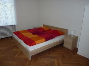 ein Schlafzimmer mit einem Bett mit einer bunten Decke in der Unterkunft Apartment Villa Elisa in Bad Kreuznach