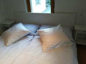 Una cama con dos almohadas encima. en Bed & Breakfast en Chur