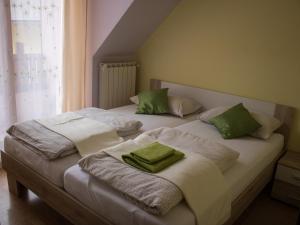 Apartments Kravanja في بوفيك: غرفة نوم بسريرين عليها وسائد خضراء