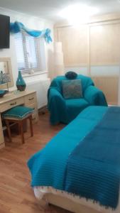 a bedroom with a blue bed and a couch at North Shore Lodge Skegness in Skegness