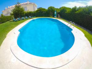 an overhead view of a large blue swimming pool at Carcavelos Surf Hostel in Carcavelos