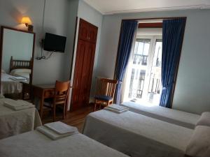 a hotel room with two beds and a mirror at Hostal Guerra in Madrid