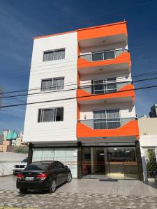 una macchina nera parcheggiata di fronte a un edificio di Hotel Luz do Sol a Balneário Camboriú