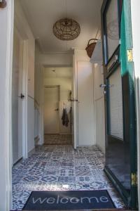 a hallway with a door and a tile floor at Huisje Linquenda in Moddergat