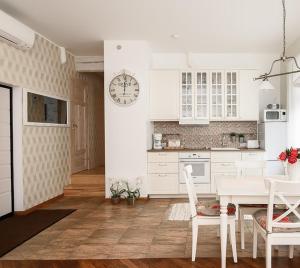 a kitchen with a table and a clock on the wall at Roosi Apartment in Pärnu