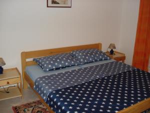 Una cama con un edredón azul con estrellas blancas. en Medel, en Medulin