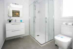 a bathroom with a glass shower and a toilet at MONKÓ - KIWI & TROPYCAL APARTMENT o in Torremolinos