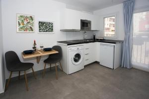 a kitchen with a washing machine and a table at MONKÓ - KIWI & TROPYCAL APARTMENT o in Torremolinos +9 photos