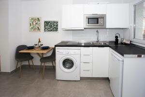 a kitchen with a washing machine and a table at MONKÓ - KIWI & TROPYCAL APARTMENT o in Torremolinos