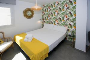 a small bedroom with a bed with a yellow and white sheets at MONKÓ - KIWI & TROPYCAL APARTMENT o in Torremolinos