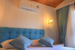 Merry Bungalow & Tent في جيرالي: غرفة نوم بسرير ازرق مع وسادتين