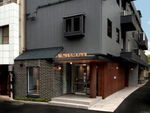 un bâtiment en briques avec un toit noir et une porte dans l'établissement ALPHABED INN Takamatsuekimae 202 / Vacation STAY 36555, à Takamatsu