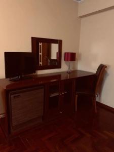 a desk with a television and a mirror in a room at Hotel Valenca do Minho in Valença