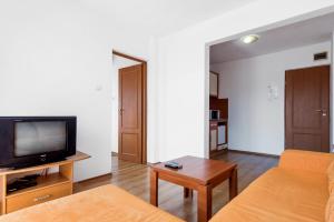a living room with a couch and a tv at Хотел Лагуна in Chernomorets