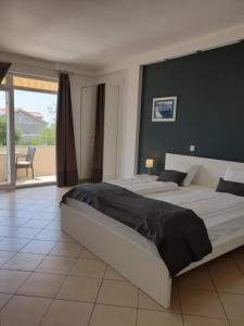 a large bedroom with two beds and a balcony at Apartment by B&D in Primošten