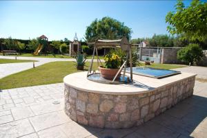 a fountain in a park with a potted plant at Villa Eleni in Drosia