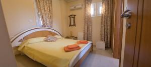 a bedroom with a bed with orange towels on it at Villa Eleni in Drosia +24 photos