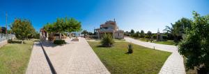 a walkway in a park with a building in the background at Villa Eleni in Drosia