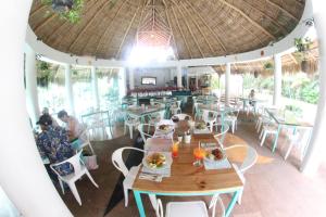 un restaurante con mesas y sillas y una sombrilla grande en Hotel Casa Iguana Mismaloya, en Puerto Vallarta