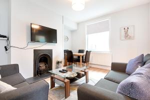 a living room with a couch and a fireplace at The Location - TV in Every Bedroom! in Swansea