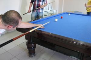 a man playing a game of pool with two cues at Trabzon Star Pension in Trabzon +10 photos
