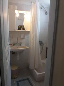 a bathroom with a shower curtain and a sink at Parasporos Village in Adamantas