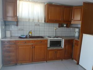 a kitchen with wooden cabinets and a stove top oven at Parasporos Village in Adamas