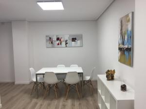 a dining room with a white table and white chairs at Garden Turia Downtown in Valencia