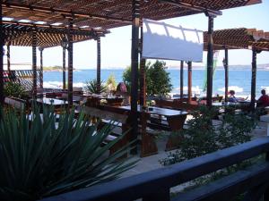 a restaurant with tables and a view of the ocean at Хотел Лагуна in Chernomorets