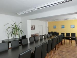 une salle de conférence avec une grande table et des chaises dans l'établissement Gästehaus Rostock Lütten Klein, à Rostock