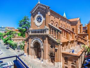 un gran edificio de ladrillo con una torre de reloj. en Le Petit Bijou, en Roma