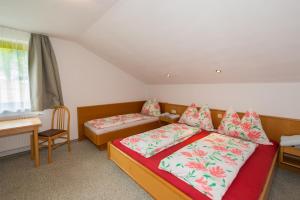 a bedroom with two beds and a table and a desk at Appartements Romantika & Appartement Barbara in Wagrain