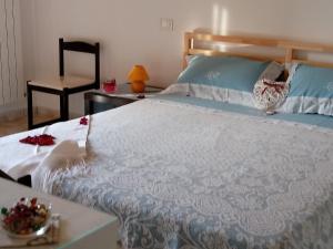 a bedroom with a large white bed with a table at B&B La Casetta in Bolognano