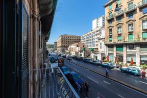 una calle de la ciudad con coches aparcados en el lateral de un edificio en Medina Central, en Nápoles