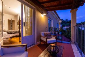 eine Veranda mit einem Sofa und einem Stuhl auf dem Balkon in der Unterkunft Geronimo Guest House Belém in Lissabon