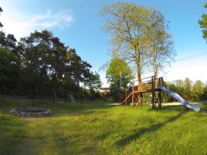 a playground with a slide in the grass at Domki letniskowe blisko plaży- Park Jantar in Jantar