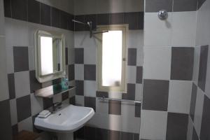 La salle de bains est pourvue d'un lavabo et de 2 fenêtres. dans l'établissement Basic 8 Bed Mixed Dorm (share Bathroom), à Naples