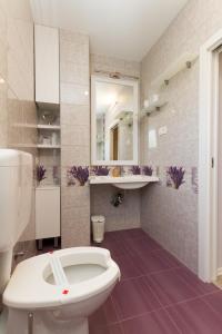 a bathroom with a white toilet and a sink at Apartmaji Sobe Zvezda in Pobegi +85 photos