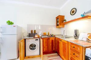 a kitchen with a white refrigerator and a washing machine at aloha apartments in Marsalforn