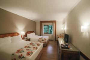 een hotelkamer met 2 bedden en een televisie bij Mabu Thermas Grand Resort in Foz do Iguaçu